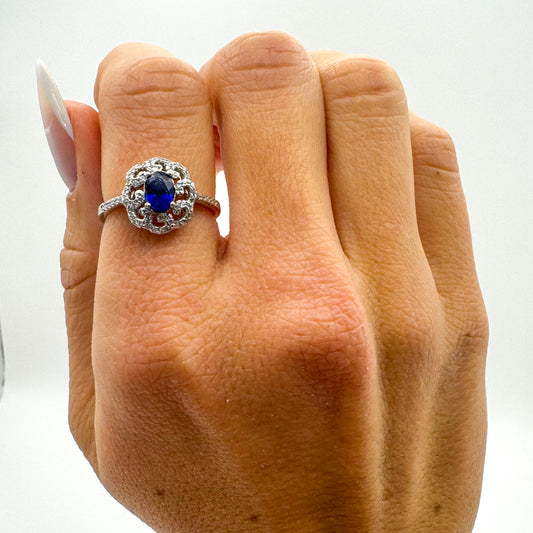 ANELLO CON ZAFFIRO OVALE E ZIRCONI BIANCHI IN ARGENTO 925 RODIATO